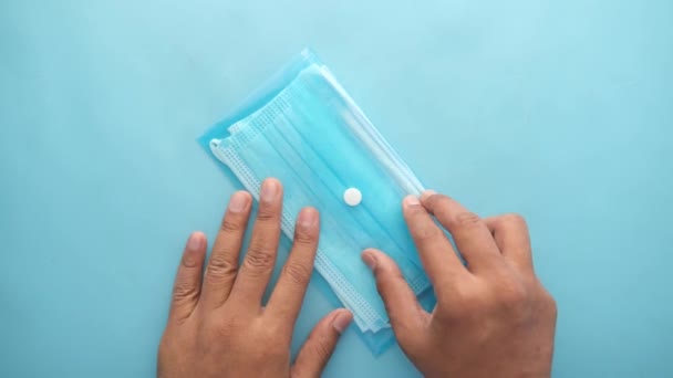 Ansicht von der Hand eines Mannes, der eine chirurgische Gesichtsmaske aus einem Päckchen nimmt — Stockvideo