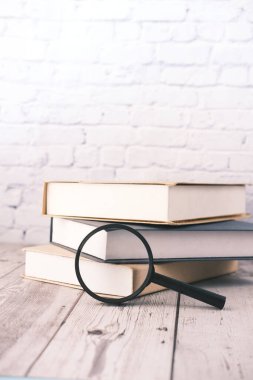 Masanın üzerinde açık kitap ve büyüteç.