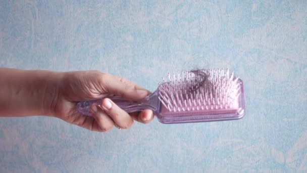 Las mujeres sostienen un cepillo con el pelo perdido — Vídeos de Stock