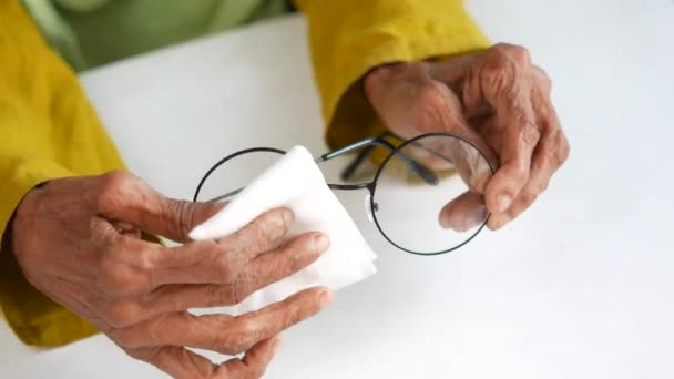 Primer plano de mujeres mayores limpiando anteojos con un pañuelo — Vídeos de Stock