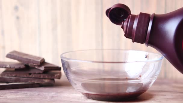 Gieten van pure chocolade crème in een kom op tafel — Stockvideo