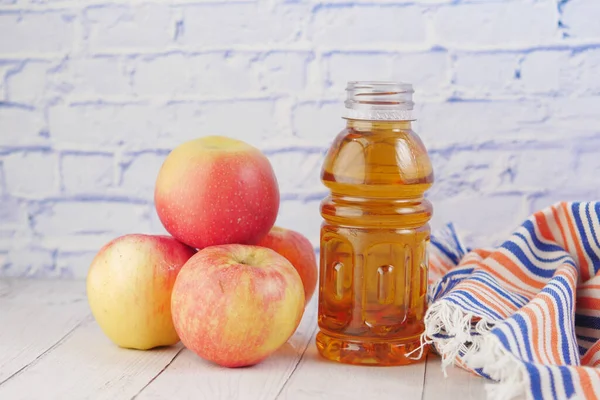 Apel segar dan sebotol jus di atas meja — Stok Foto