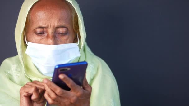 Ηλικιωμένες γυναίκες με μάσκα προσώπου χρησιμοποιώντας έξυπνο τηλέφωνο — Αρχείο Βίντεο