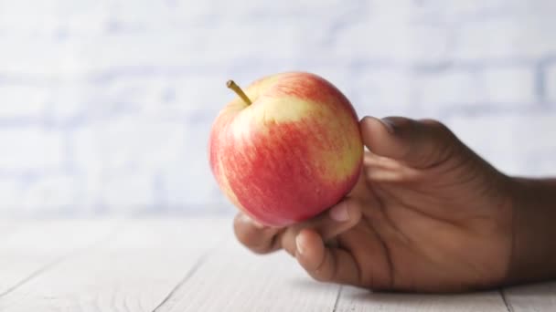 Niño niño mano mantenga una manzana sobre fondo azul — Vídeos de Stock