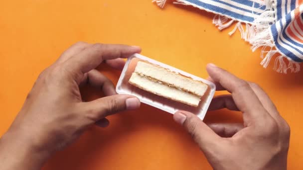 手从塑料容器中挑出一块巧克力蛋糕 — 图库视频影像