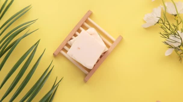 Ręcznie wybrać domowej roboty naturalny mydło bar i suchy kwiat na żółtym tle — Wideo stockowe