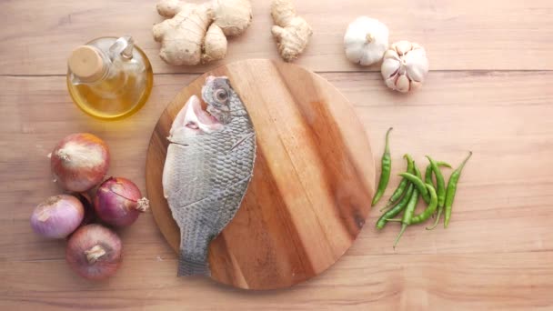 Pescado fresco crudo en una tabla de picar para prepararse para cocinar en la mesa , — Vídeo de stock