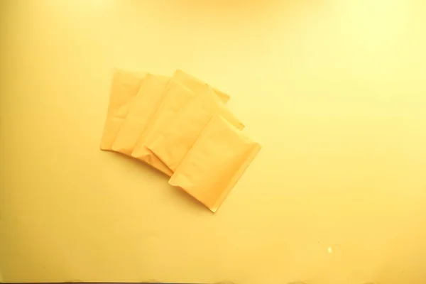 Žlutá papírová bublina obálka na stole — Stock fotografie