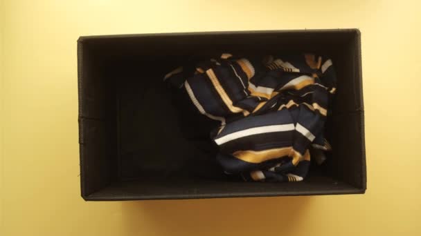 Коробка для пожертвований с одеждой для пожертвований на желтом фоне — стоковое видео