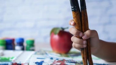 çocuk eli fotokopi alanı olan bir kağıt üzerinde birçok sanat fırçası tut ,