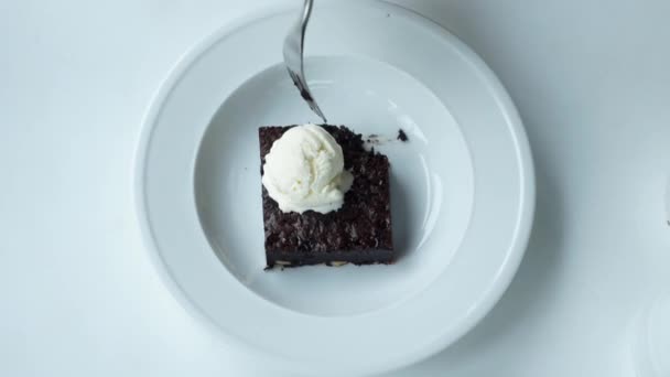 Ansicht von Eiscreme-Brownie auf Teller auf weißem Hintergrund — Stockvideo