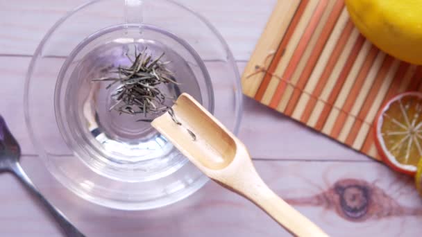 Verter hojas de té secas en una taza de té vista superior — Vídeos de Stock