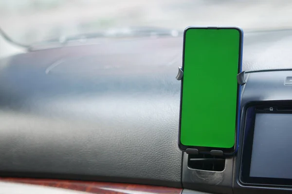 Chytrý telefon se zelenou obrazovkou na palubní desce — Stock fotografie