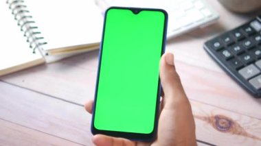 El kamerasının arka görüntüsü ofis masasındaki akıllı telefonu tut 