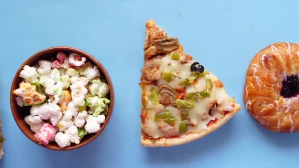 盘子里的奶酪比萨饼、甜甜圈和蓝色爆米花 — 图库视频影像