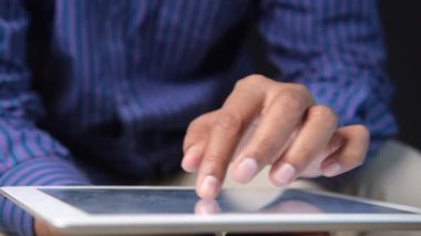 Otururken dijital tablet kullanan işadamı 