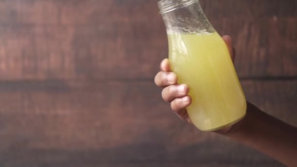 Hand houden een fles ananas sap — Stockvideo