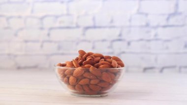 Masadaki bir kaseden elle badem fıstığı topla. 