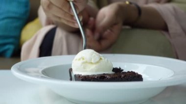 Kadınlar tabakta brownie yiyorlar. 