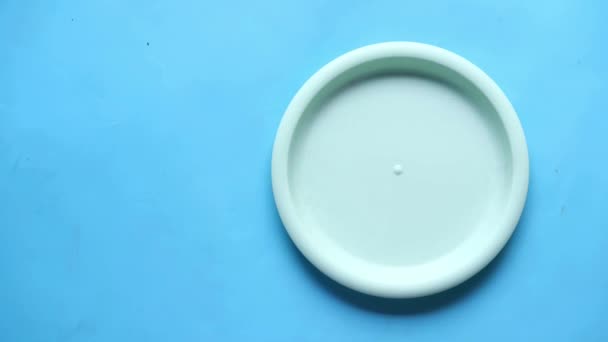 다 채로운빈 접시를 탁자 위에 놓는 모습 — 비디오