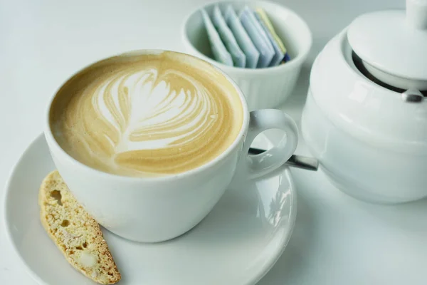 Una taza de café tardío con diseño de forma de flor en la parte superior en la cafetería — Foto de Stock