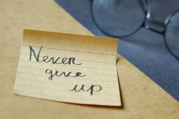 Never give up word on stick note on table , — Stock Photo, Image