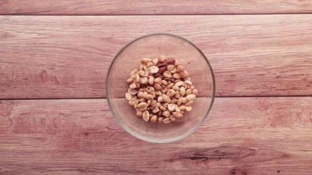 Gieten Verwerkte erwten noten in een kom op tafel naar beneden . — Stockvideo