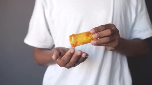 Férfiak kéz gyógyszer kiömlött a tablettatartályból — Stock videók