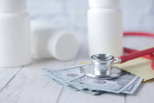 Концепция затрат на здравоохранение с нами доллар, контейнер и таблетки на столе — стоковое фото