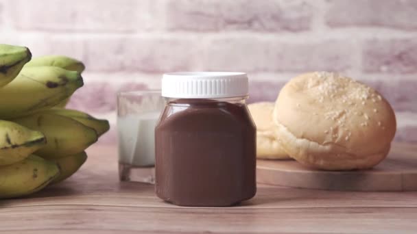 Шоколадный крем из ореха в контейнере на столе — стоковое видео