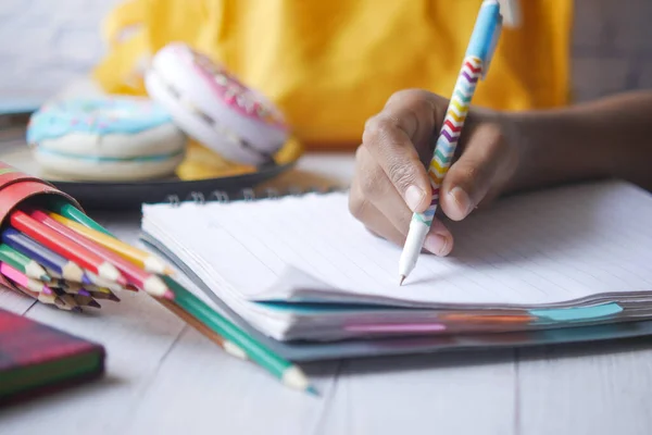 Kinderhand schrijven op notitieblok — Stockfoto