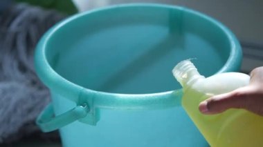  Bir kovada yer temizleme dezenfektanı doldurmak 