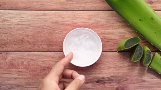 흰 바탕에 플라스틱 용기에 얇게 썰어서 액체 젤을 넣은 신선 한 알로에 베라 — 비디오