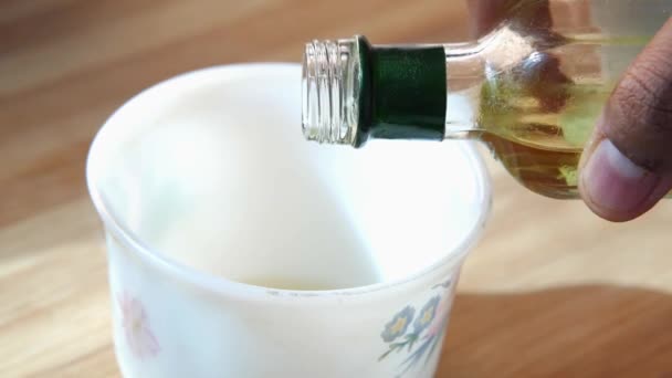 Verter aceite de girasol en una taza sobre la mesa — Vídeo de stock
