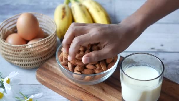 Recoger a mano nueces de almendras en la mesa — Vídeos de Stock