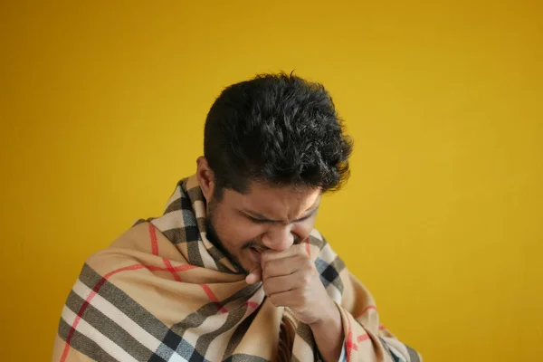 Jonge zieke man hoesten en niest tegen gele rug gorund — Stockfoto