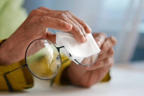 Primo piano delle donne anziane che puliscono a mano vecchi occhiali — Foto Stock