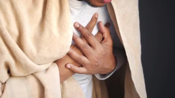 Молодой человек страдает болью в сердце и держит грудь рукой — стоковое видео
