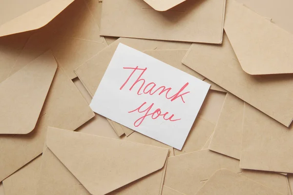 Thank you message and envelope on wooden table Royalty Free Stock Photos