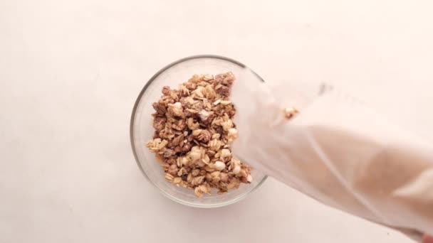 Hälla musli flingor i en skål på bordet — Stockvideo