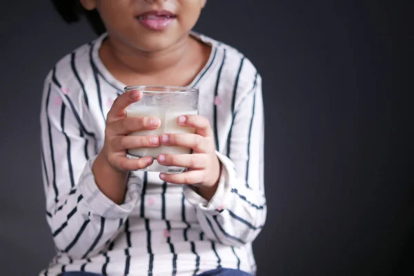 Child girl drinking milk while sited — Stock Photo, Image
