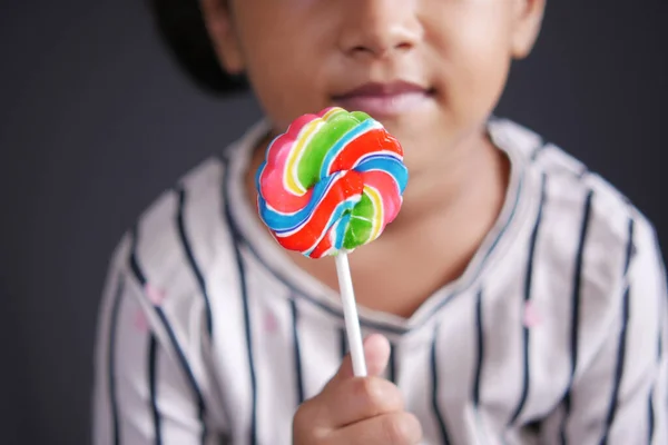 Hand hold rainbow heart shape lollipop — Stock Photo, Image