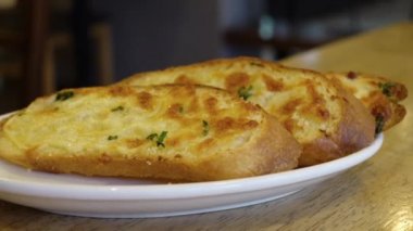 Tabağa sarımsaklı ekmek koy. 