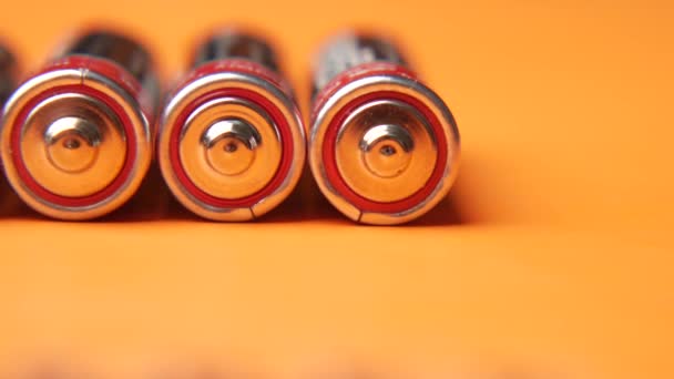 Close-up van Batterijen op oranje achtergrond — Stockvideo