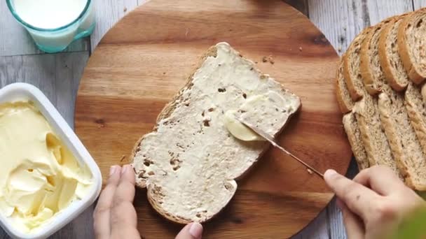 Namazání másla na chleba na sekací desku — Stock video