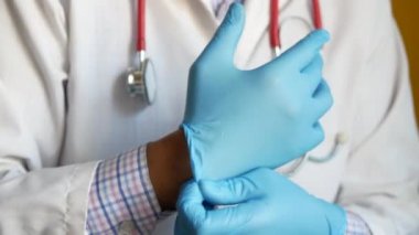 Erkek doktor tıbbi eldiven giyer, yakın plan.
