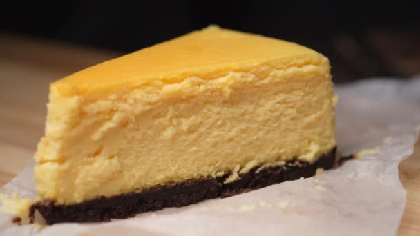 Krájení plátek sýrového dortu s lžičkou na stole — Stock video