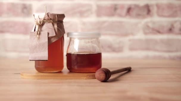 Φρέσκο μέλι σε γυάλινο βάζο με χάρτινη άδεια ετικέτα — Αρχείο Βίντεο