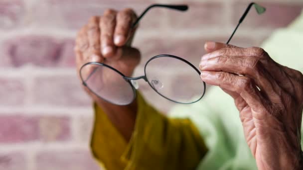 Крупним планом рука старших жінок тримає старе окуляри — стокове відео
