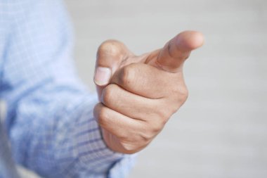 Takım elbiseli genç işadamı kameraya işaret ediyor.,